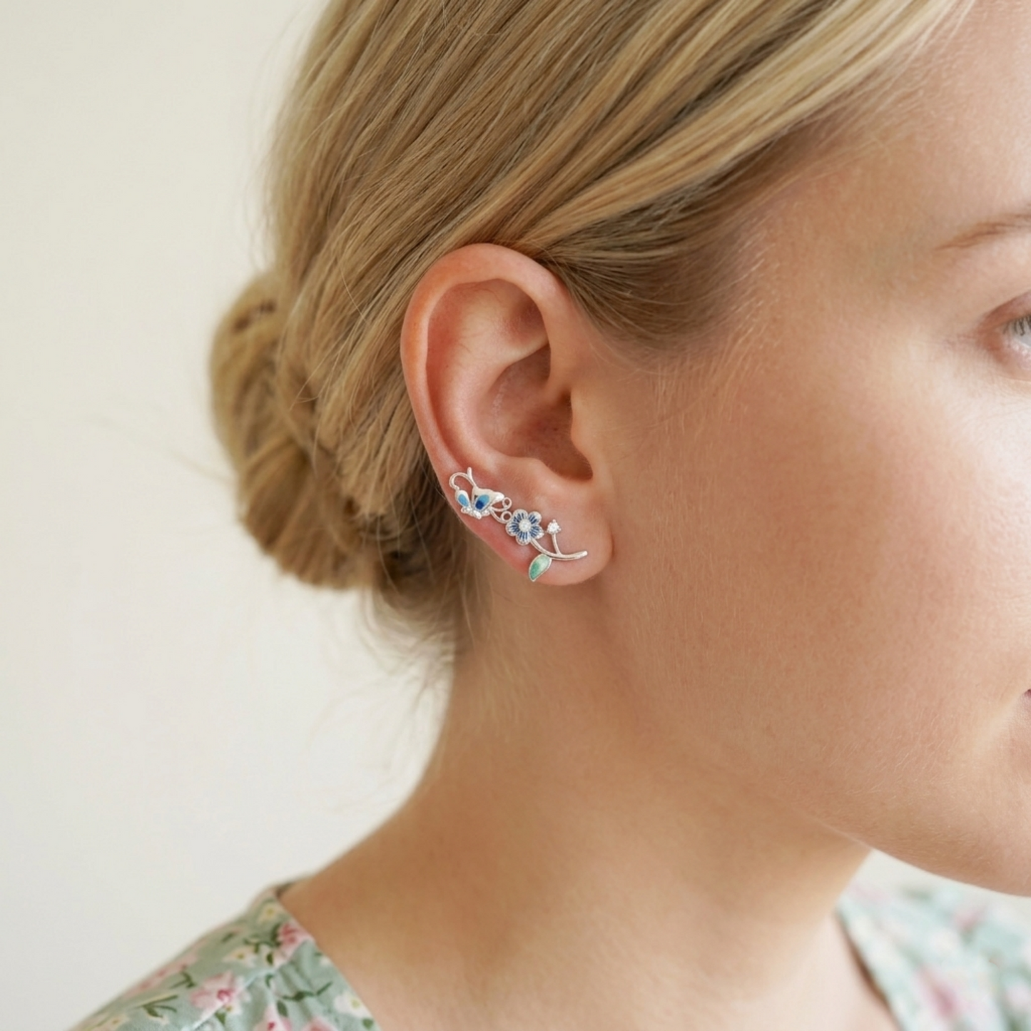 Silver butterfly climber earring with blue enamel flower and green drop detail