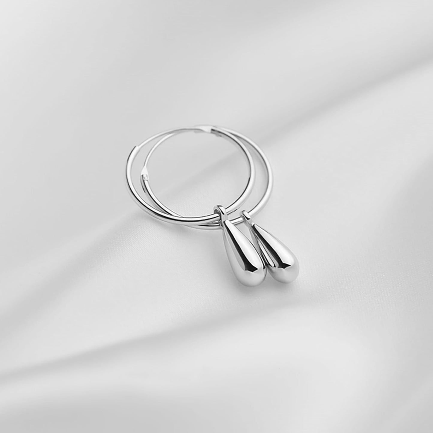 Silver teardrop hoop earrings, front view with glossy teardrop dangles