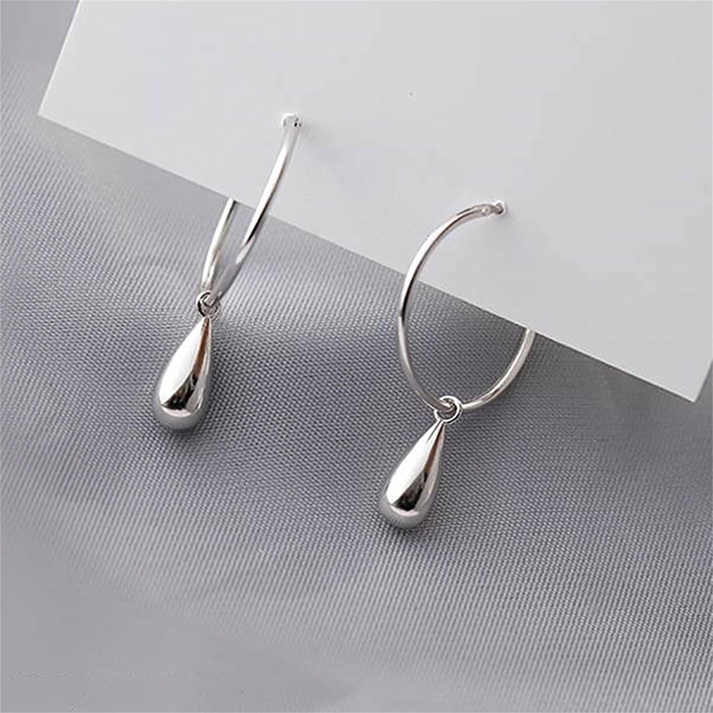 Silver teardrop hoop earrings, angled view with hanging drop details