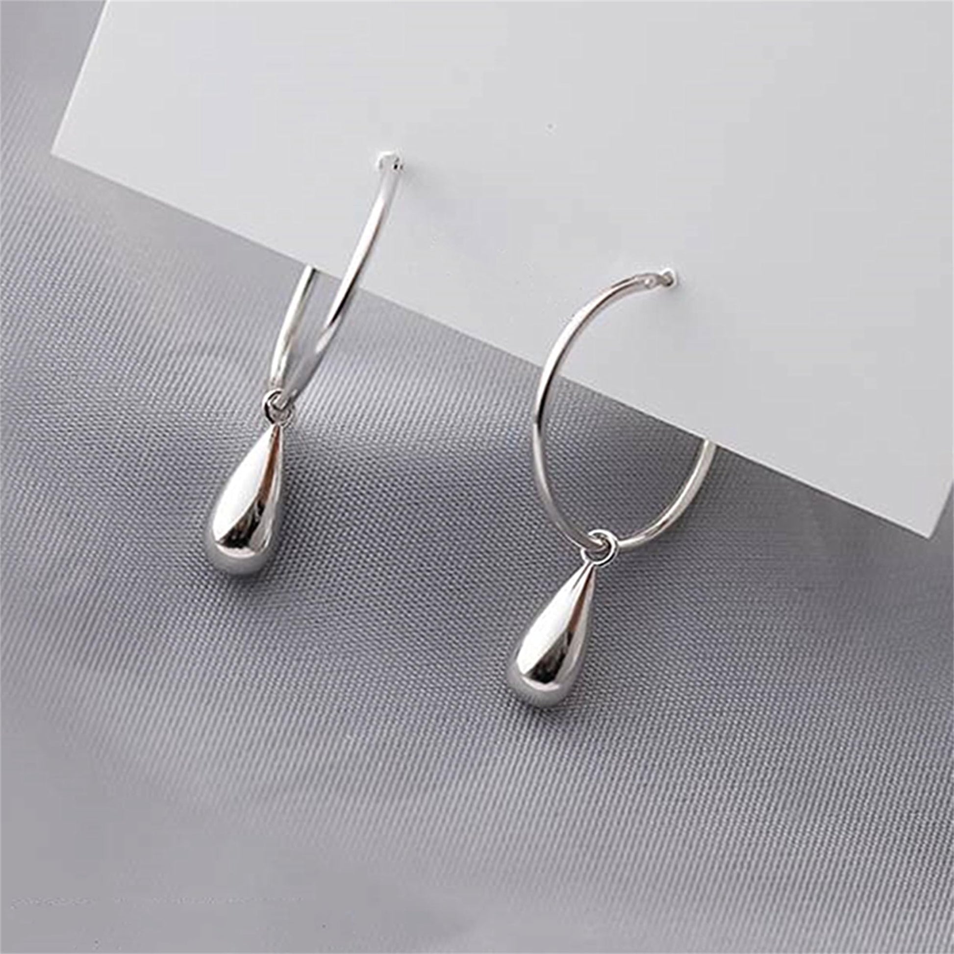 Silver teardrop hoop earrings, angled view with hanging drop details