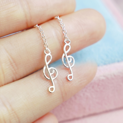 Silver music-note dangle threader earrings with connected chain and treble-note charms