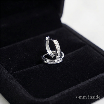 Rhodium huggie hoop earrings with a row of inset stones, side view
