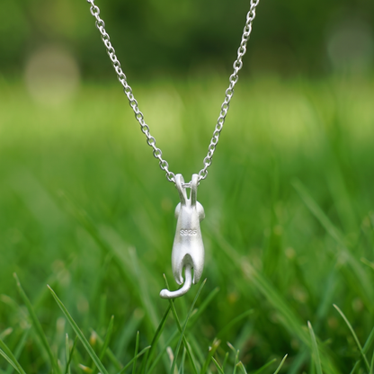 Cat pendant necklace with hanging cat charm and ring detail, silver tone