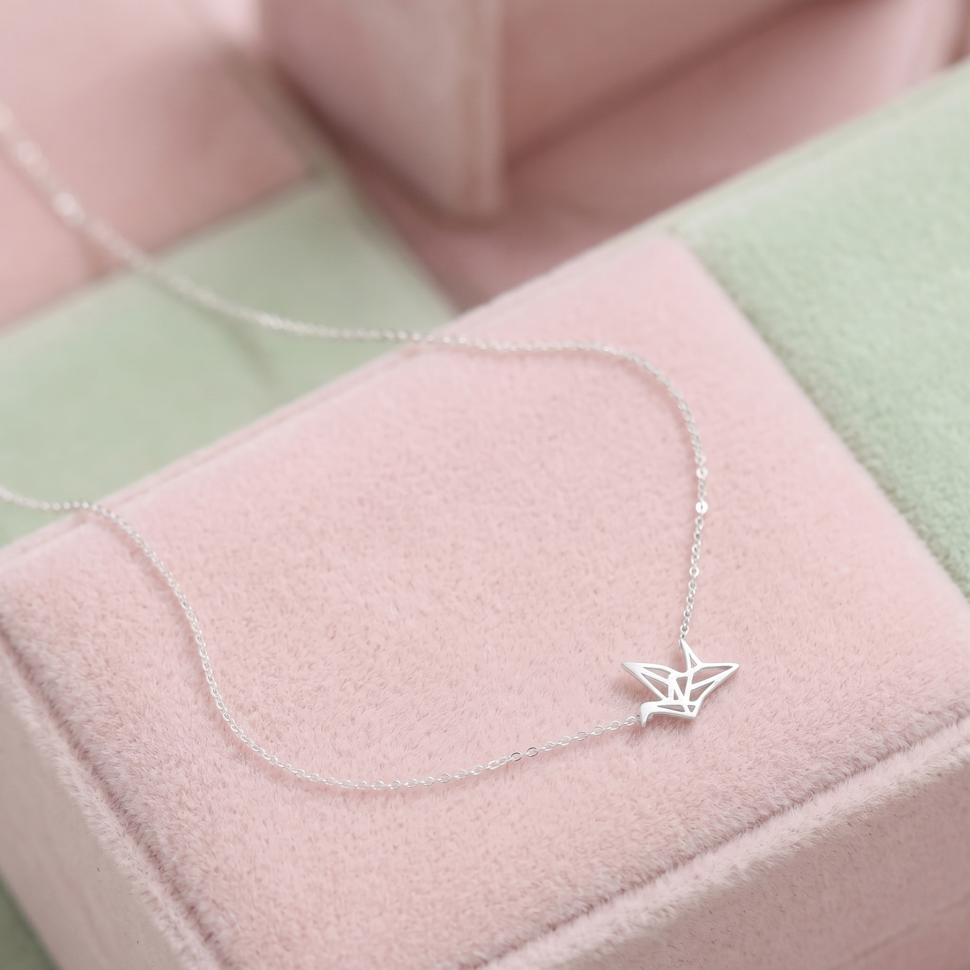 Origami crane necklace on soft fabric: silver-tone crane pendant on chain
