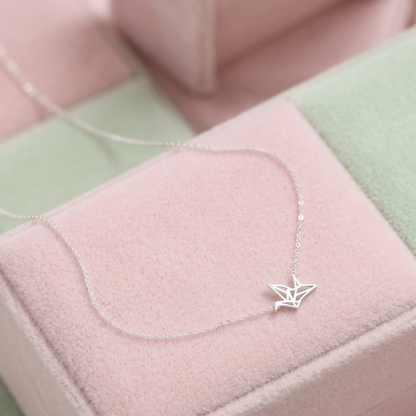 Origami crane necklace on soft fabric: silver-tone crane pendant on chain