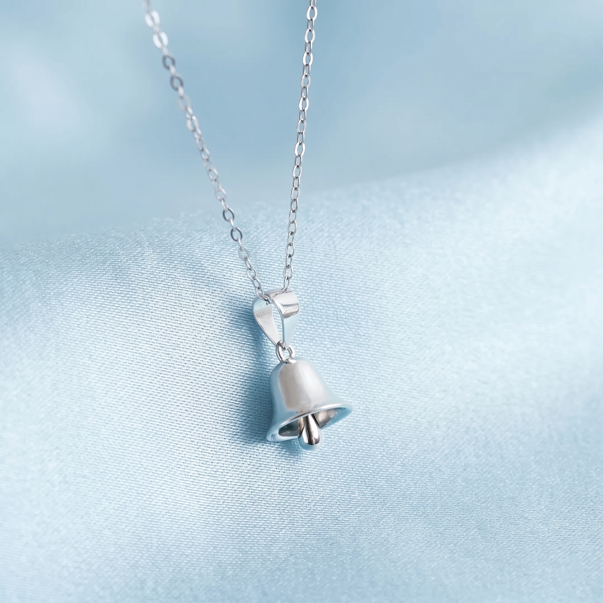 Jingle bell pendant necklace, small bail holding a polished silver bell on link chain