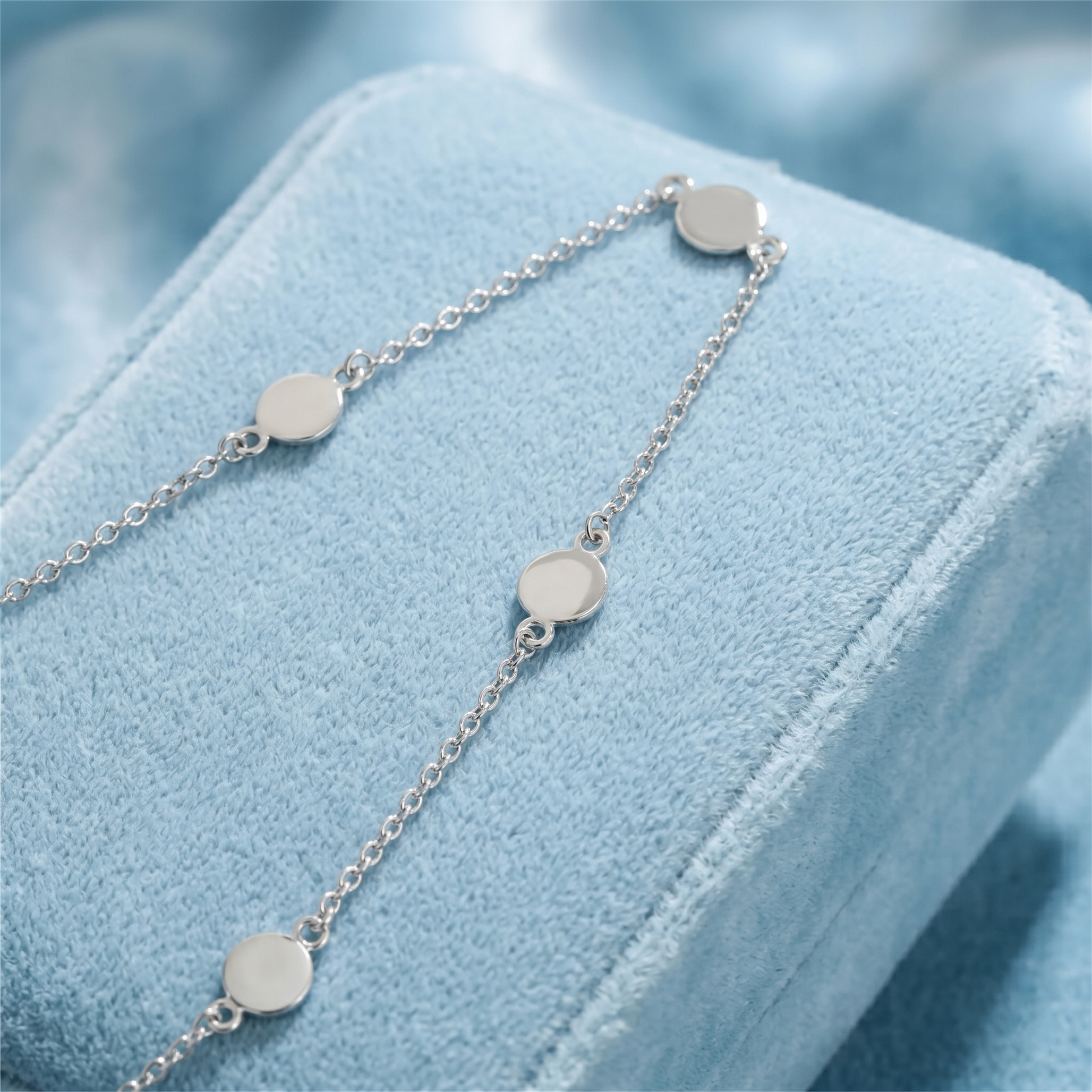 Round silver disc choker necklace with delicate link chain, close-up