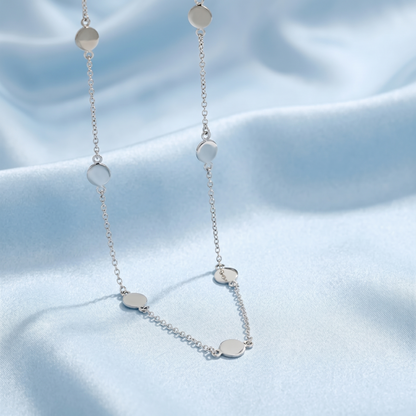 Multi-disc choker necklace featuring evenly spaced round silver discs and chain