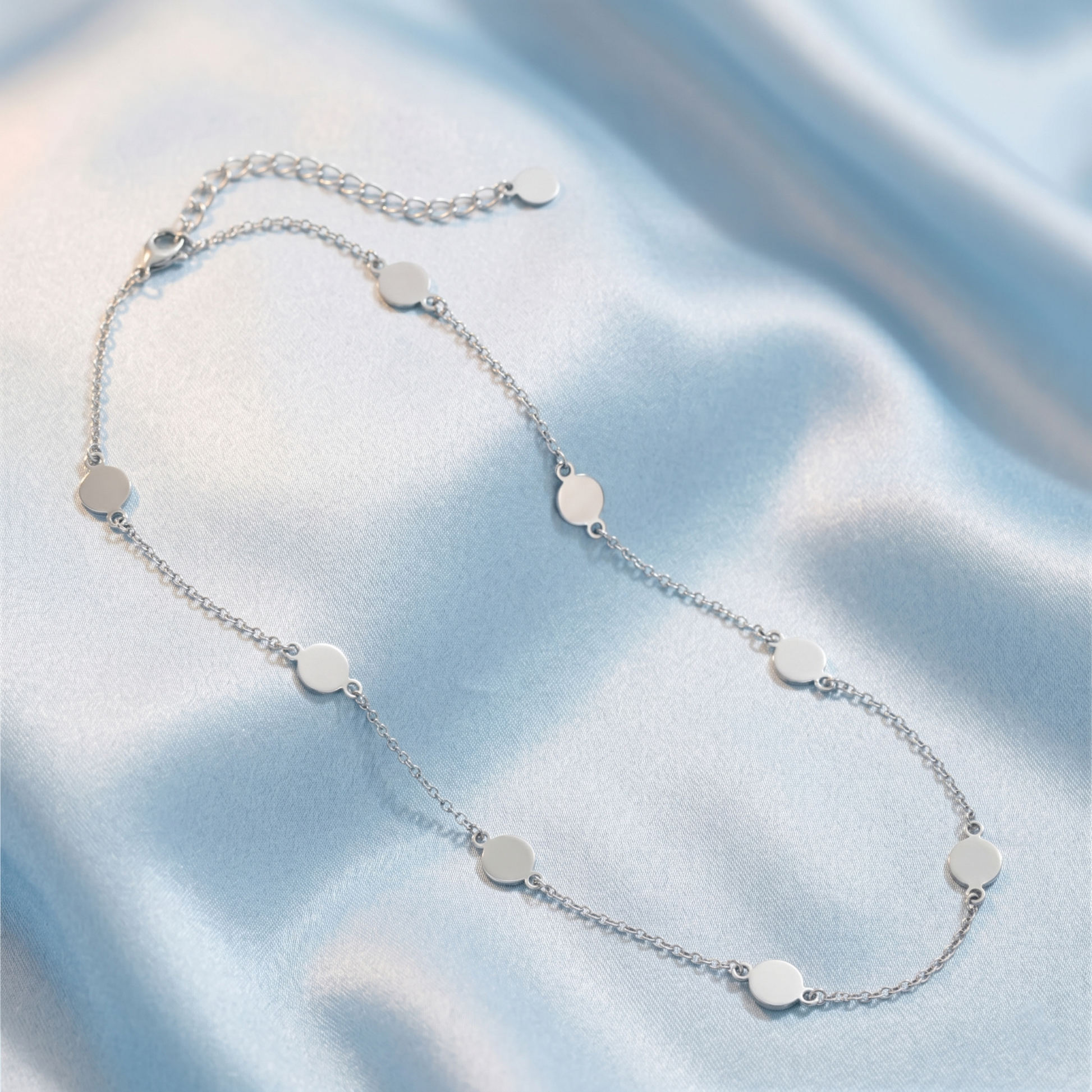 Multi-disc choker necklace with evenly spaced round silver discs on a link chain