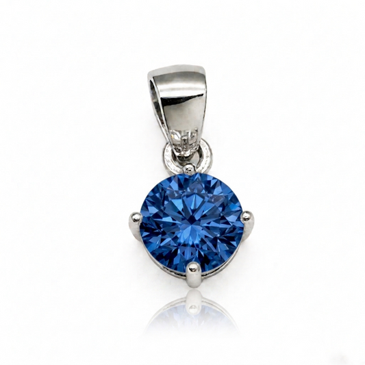 Round blue CZ solitaire pendant with silver-toned bezel and bail, on a small chain loop.