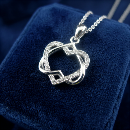 Silver heart knot pendant necklace close-up with glitter accents