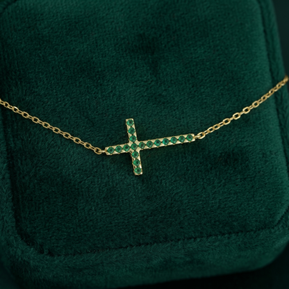 Gold-tone cross CZ necklace with green crystal stones and fine chain, close-up
