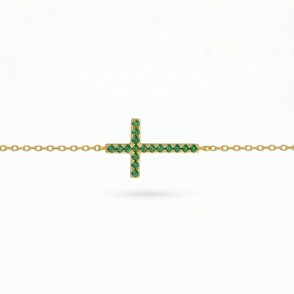 Gold-tone cross necklace with green crystal stones on a chain, side view