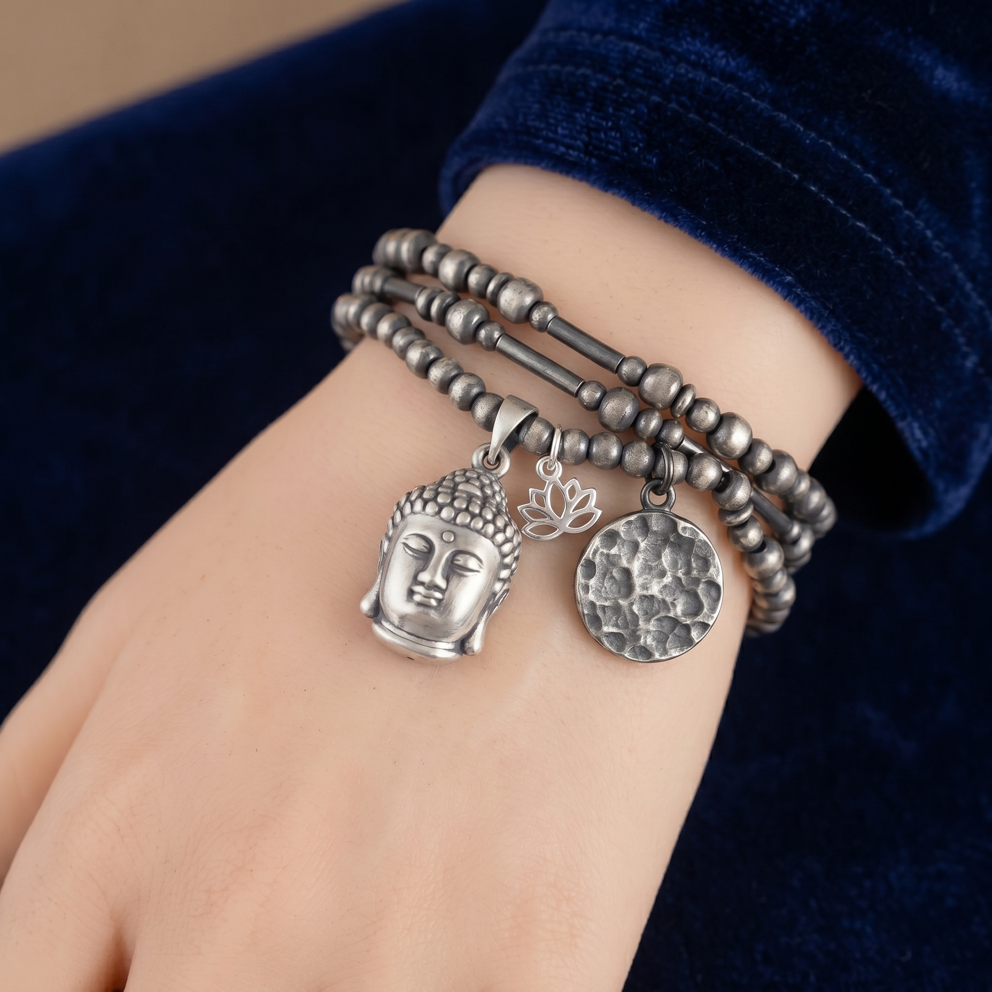 Buddha head charm pendant on stacked bead bracelet, silver-tone