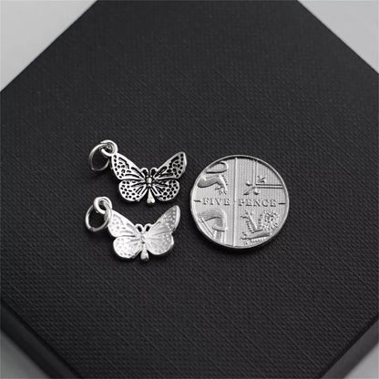 Silver butterfly charm pendant with openwork detailing and loop bail, close-up