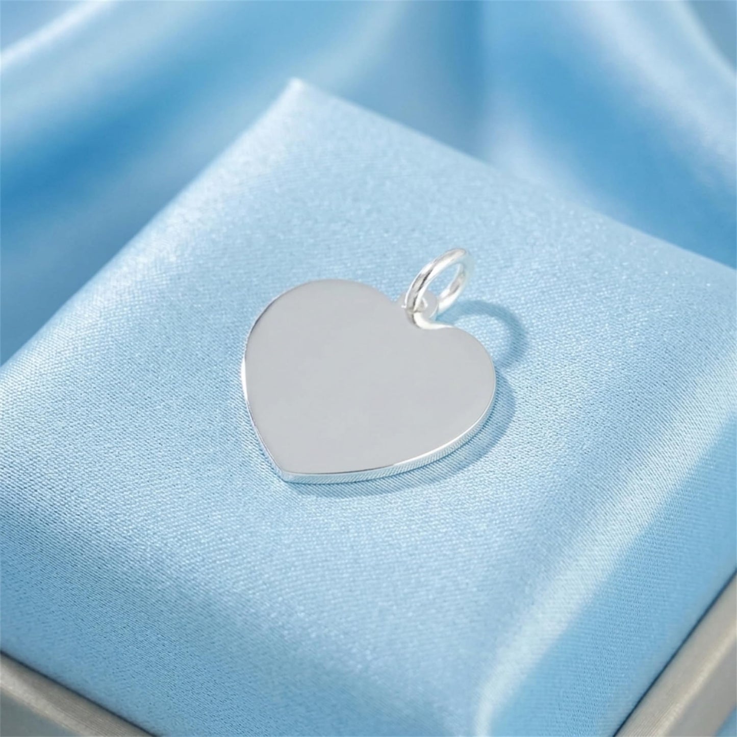 Heart pendant with polished silver loop, smooth white heart face on jewelry cushion