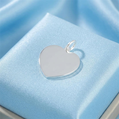 Heart pendant with polished silver loop, smooth white heart face on jewelry cushion