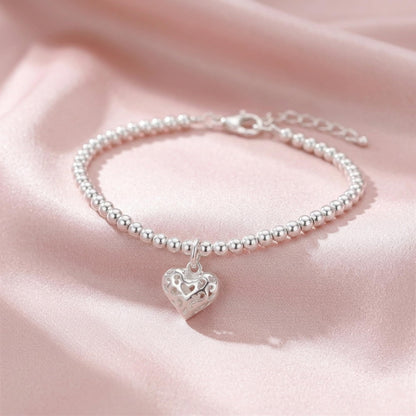 Silver beaded bracelet with a filigree heart charm drop