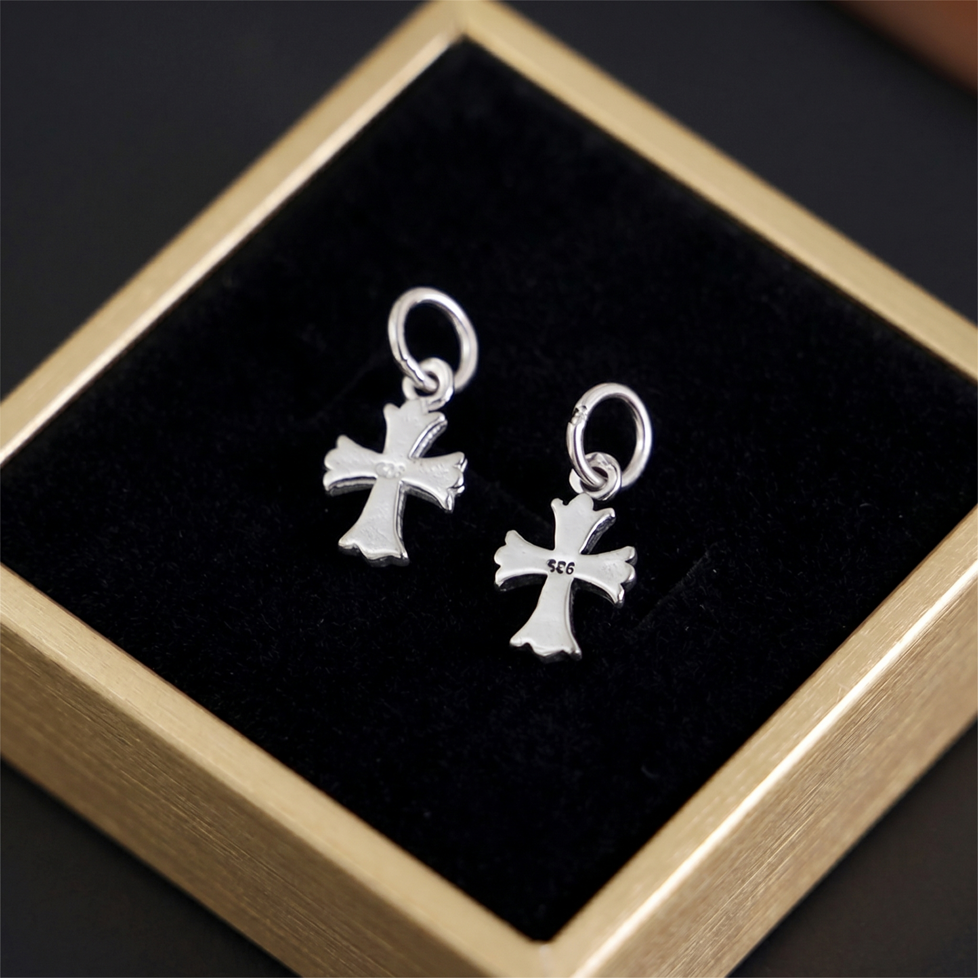 Fleur-de-lis cross charm hook earrings, plain silver pair on display