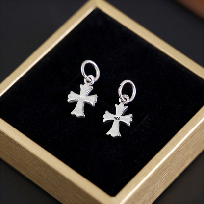 Fleur-de-lis cross charm hook earrings, plain silver pair on display