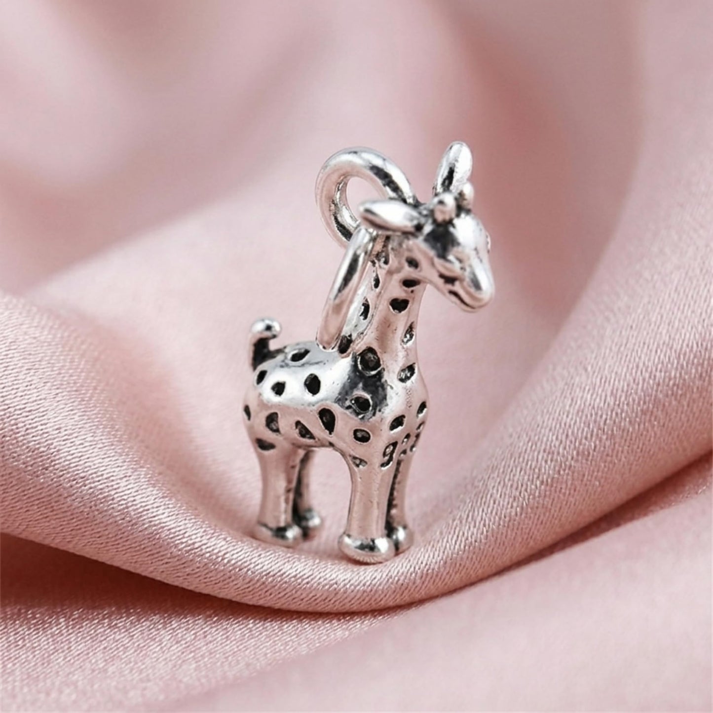 3D-Giraffen-Anhänger mit langen Beinen, silberfarbene Oberfläche und schwarze Punkte