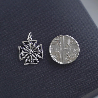 Oxidised Maltese star pendant beside coin-style reverse charm, silver tone