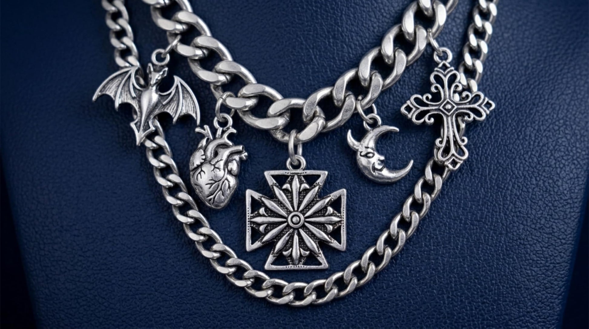 Oxidised Maltese star pendant shown among layered silver chains and charms