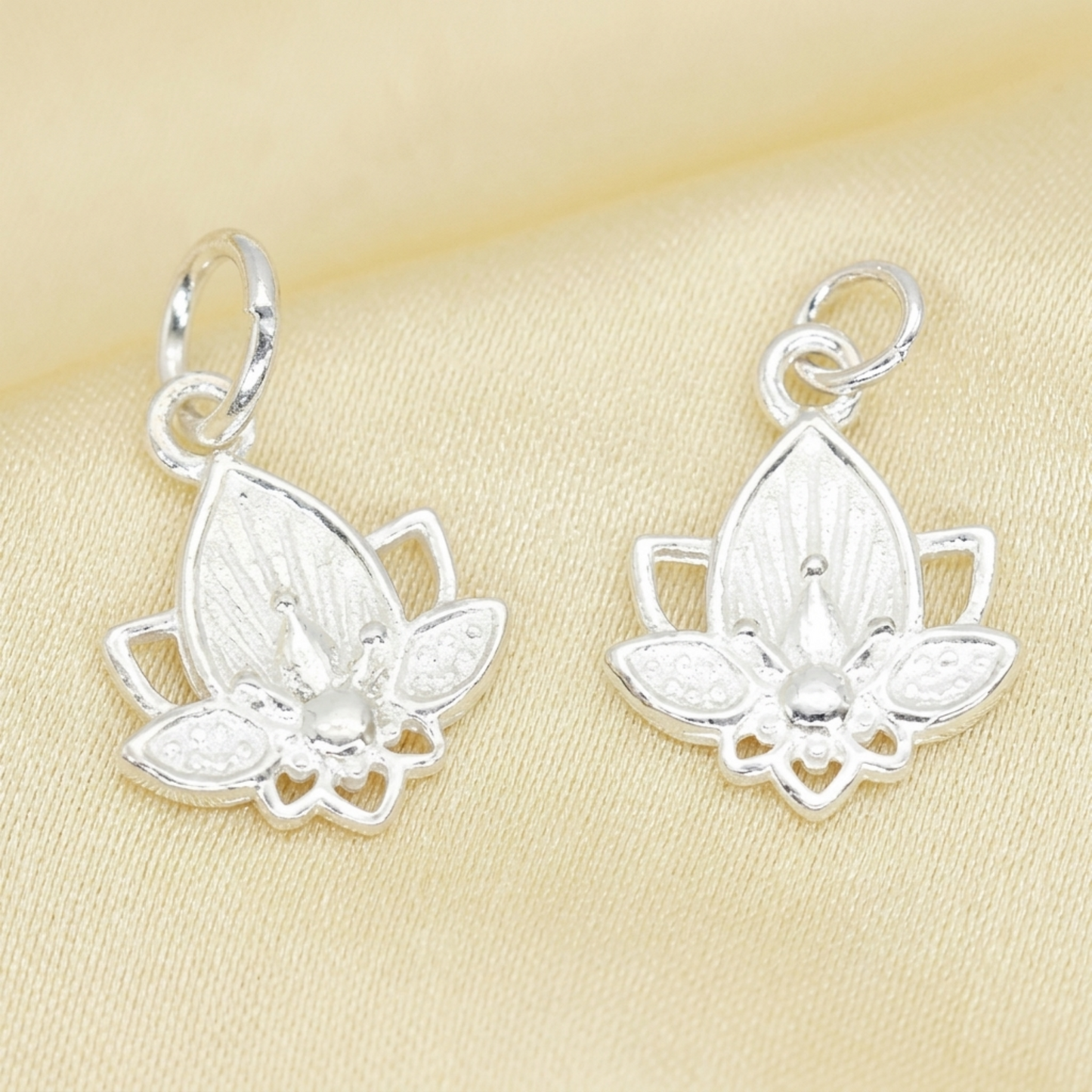 Lotus flower charm earrings in silver tone, two small lotus drops with loops