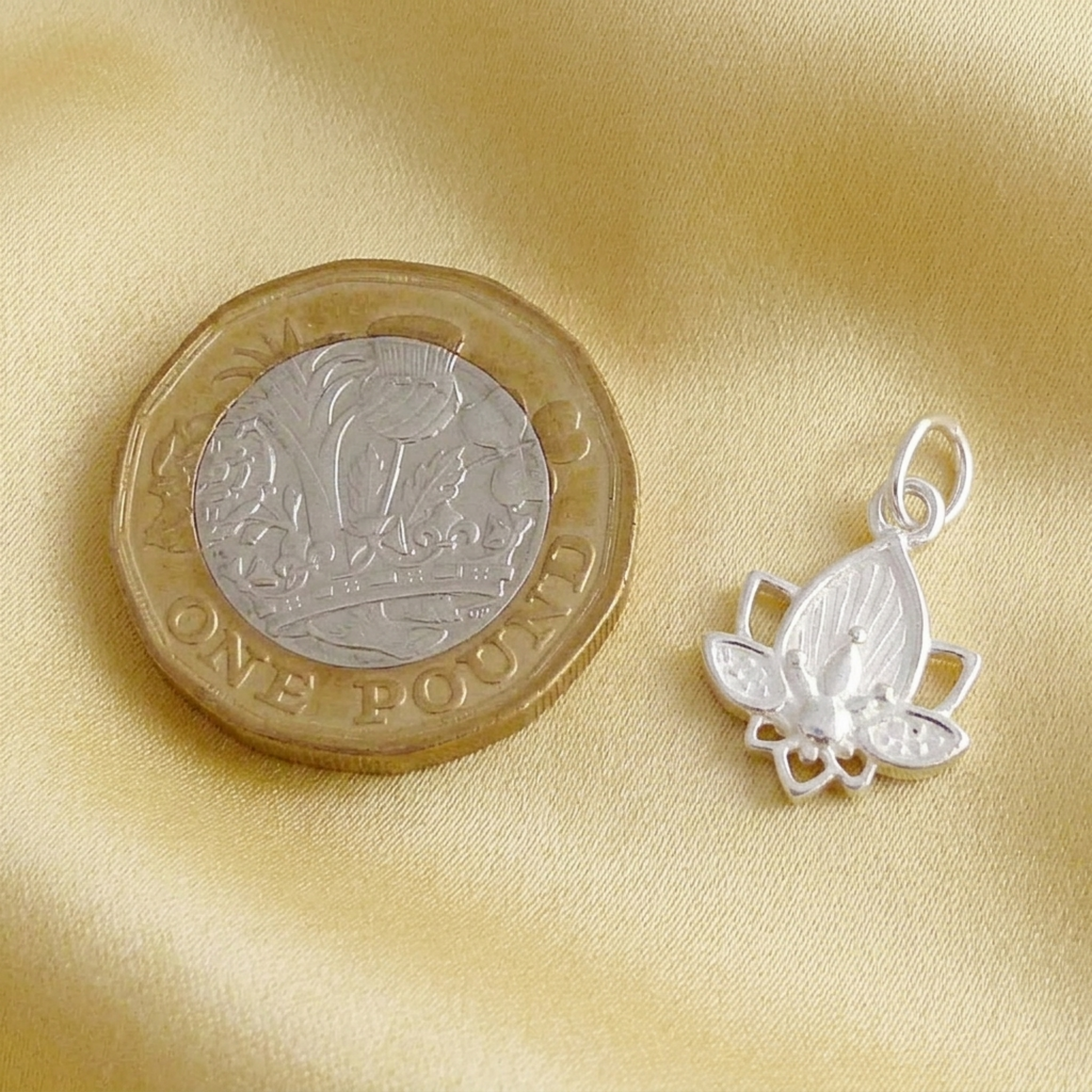 Lotus flower charm pendant close-up in silver tone with loop bail and lotus petals