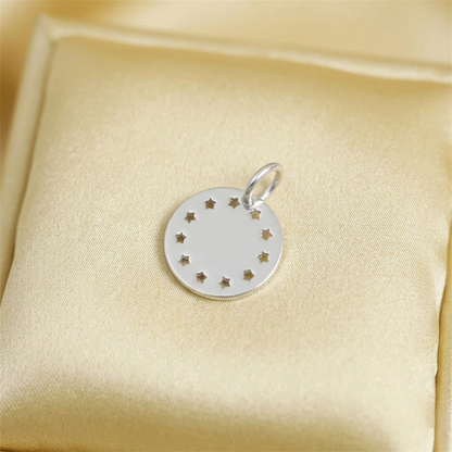 Small silver round charm disc with star cutouts and a top hanging loop