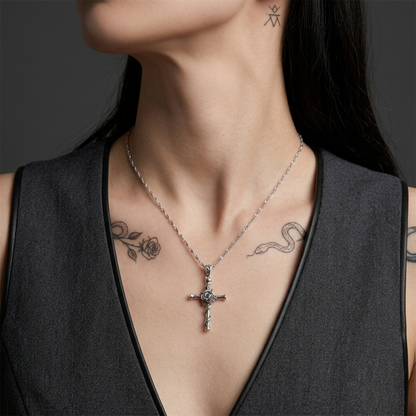 Silver chain necklace with rose thorn cross pendant at the center