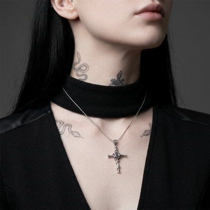 Rose thorn cross pendant on a silver chain necklace at the collar
