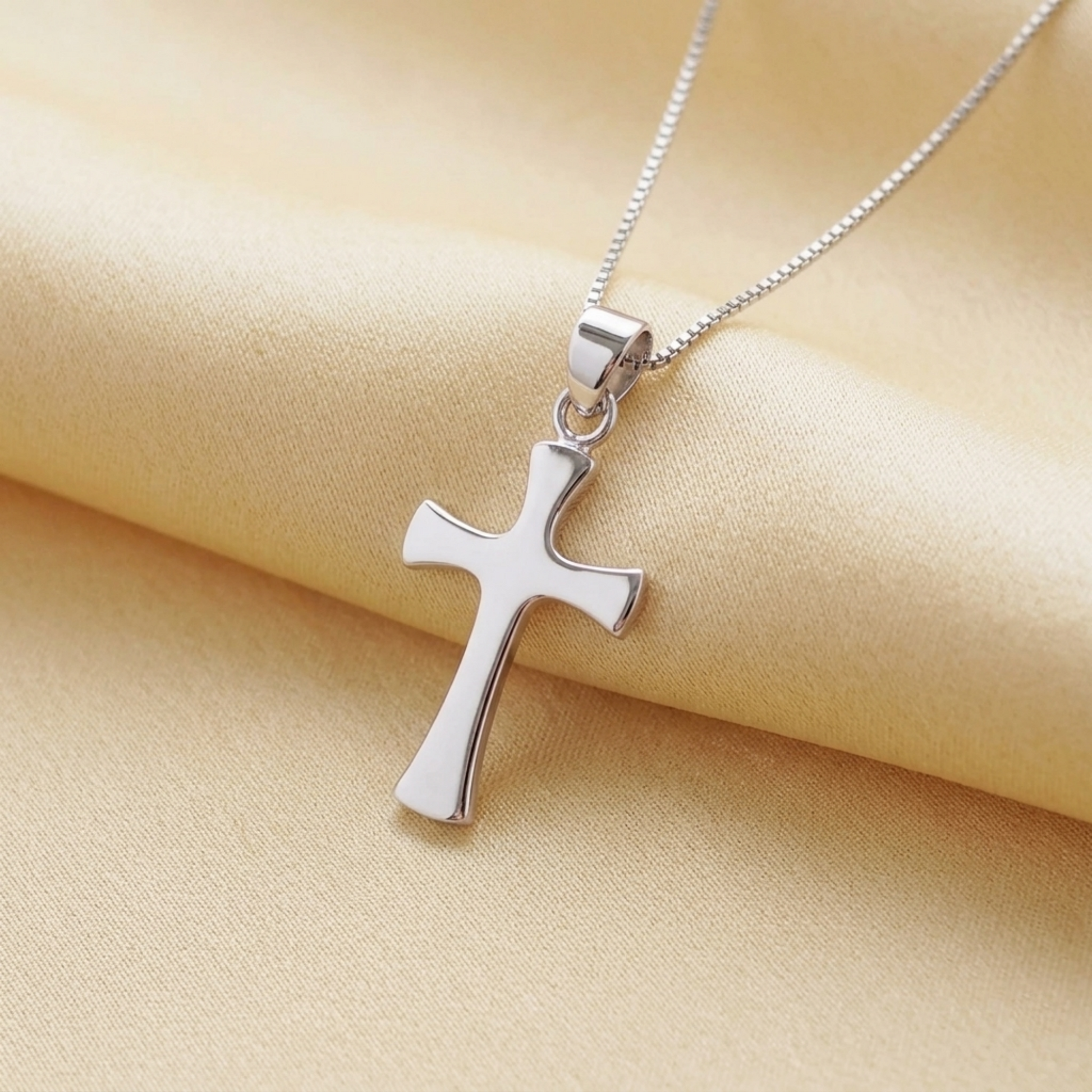 Polished cross pendant on a silver chain necklace, close-up view