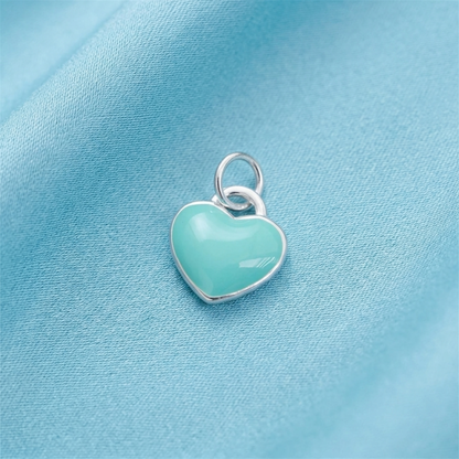 Turquoise glazed heart charm with silver ring loop, rounded puffy shape