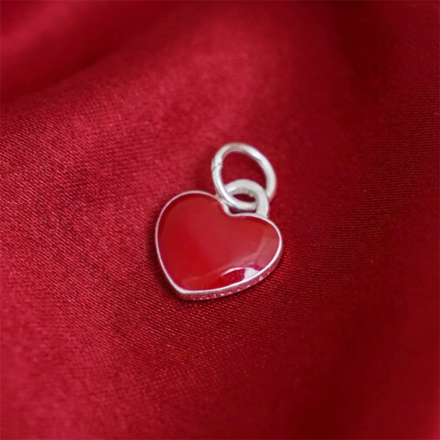 Red heart charm pendant with silver outline and small loop
