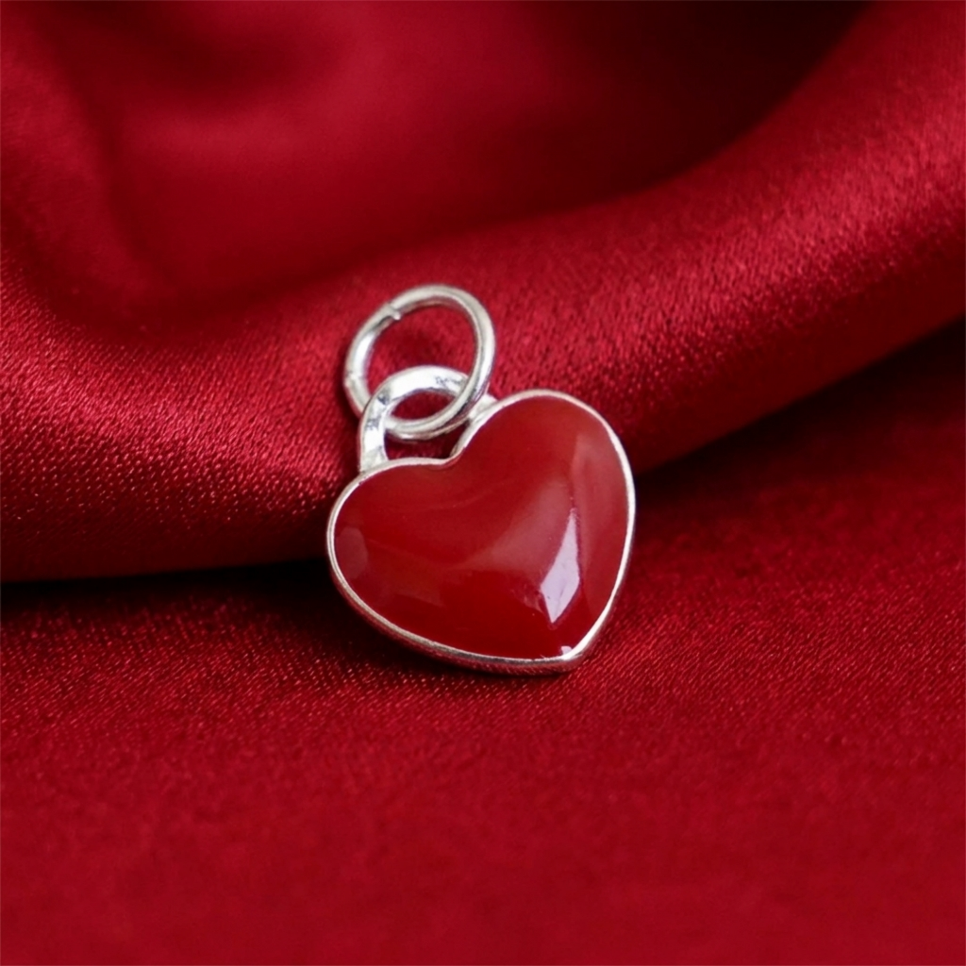 Red heart charm pendant with silver loop and glossy surface