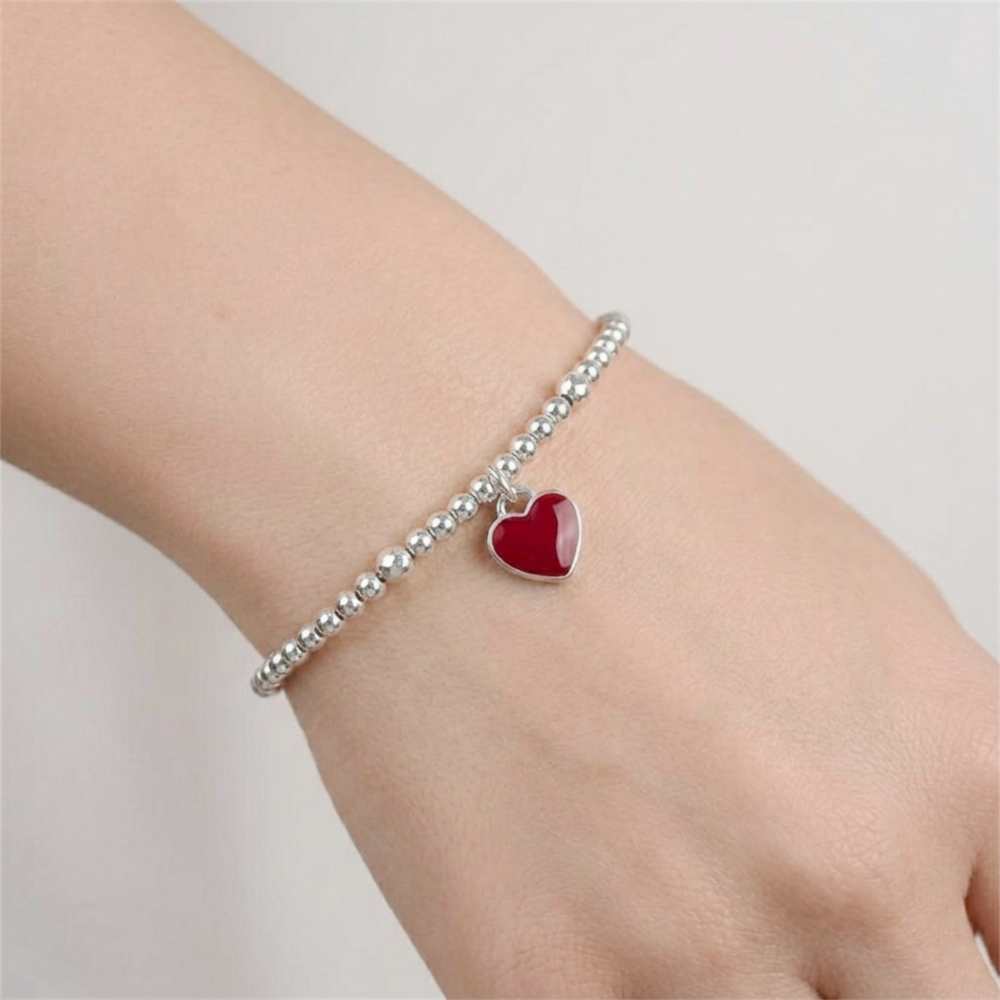 Silver beaded bracelet with small red heart charm