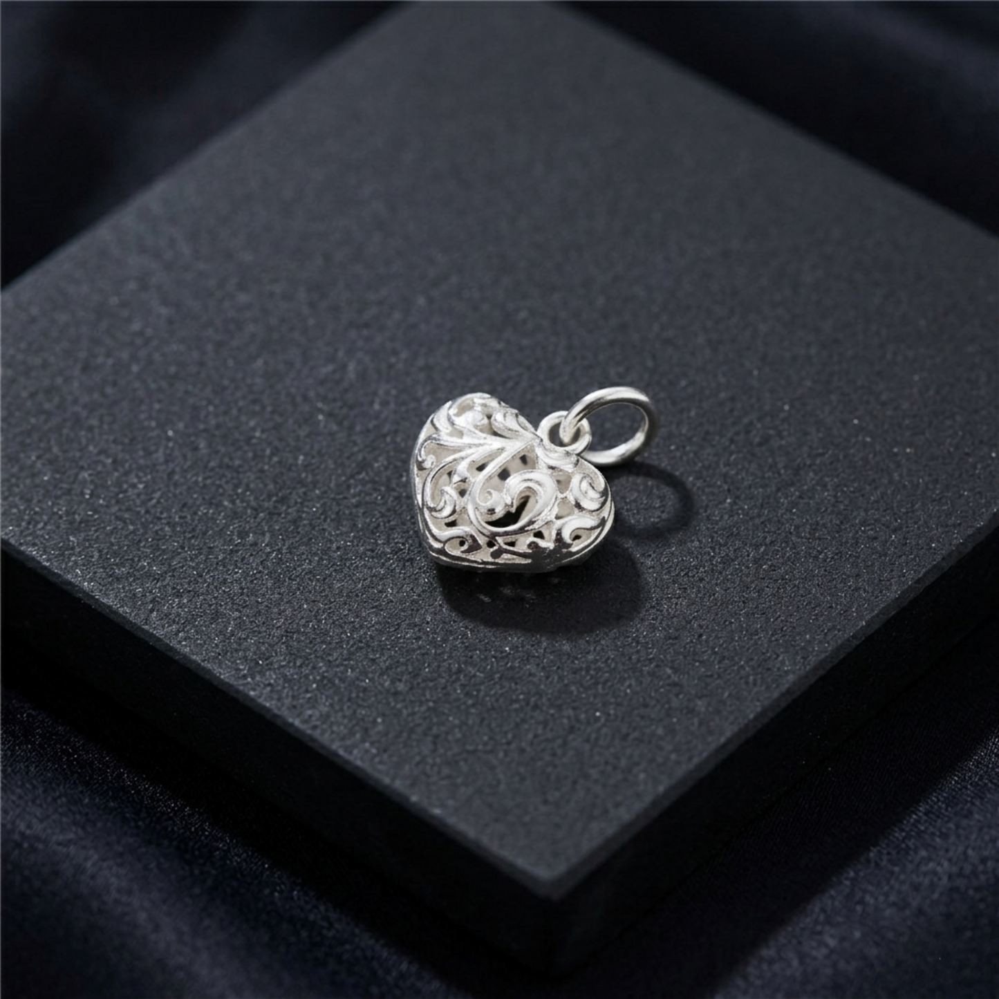 Silver heart charm pendant with filigree floral pattern and small bail