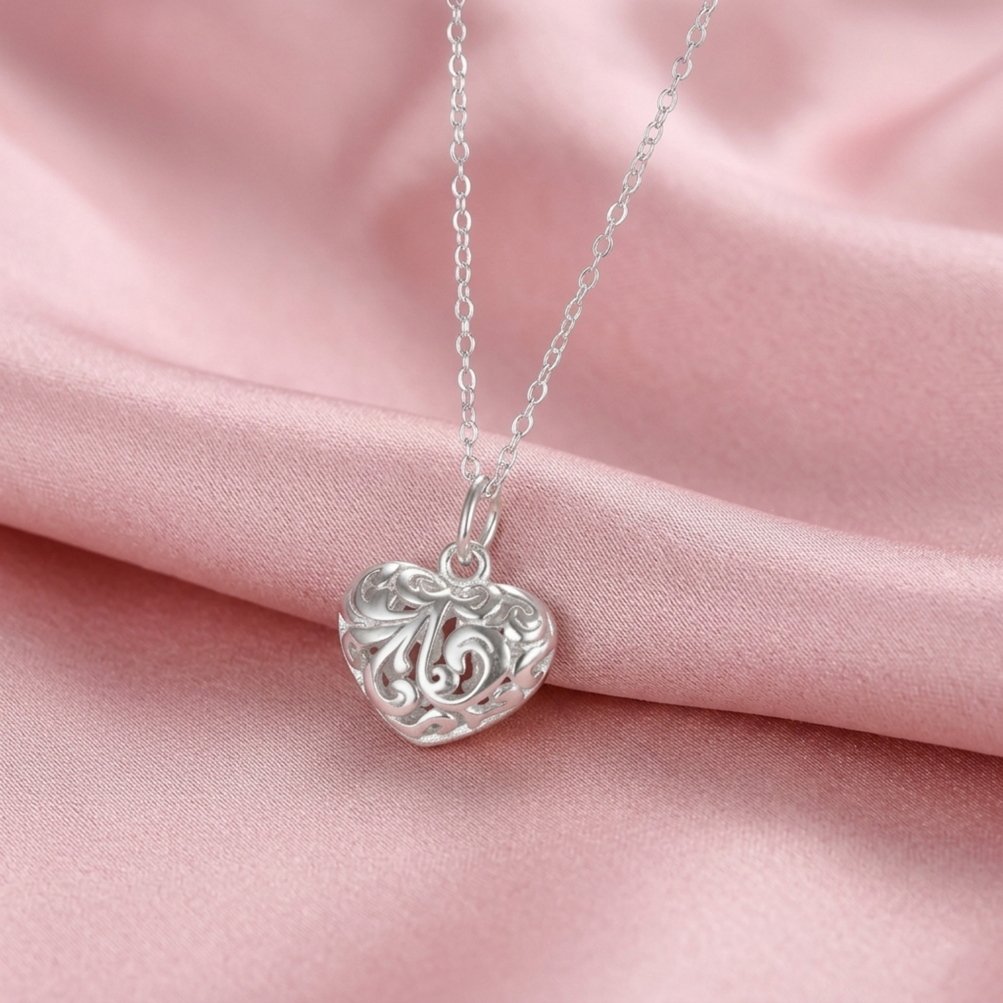Silver heart pendant on chain with filigree floral cutout heart face