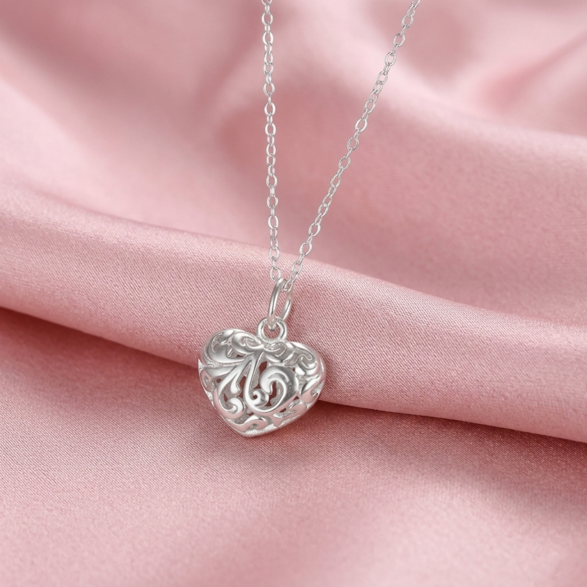 Silver heart pendant on chain with filigree floral cutout heart face