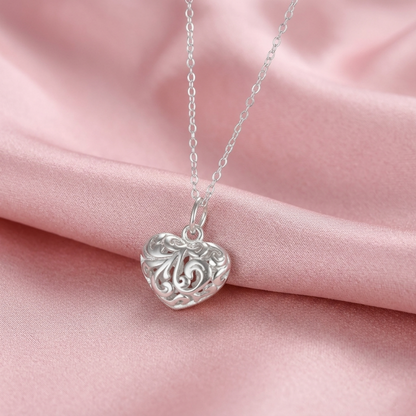 Silver heart pendant on chain with filigree floral cutout heart face