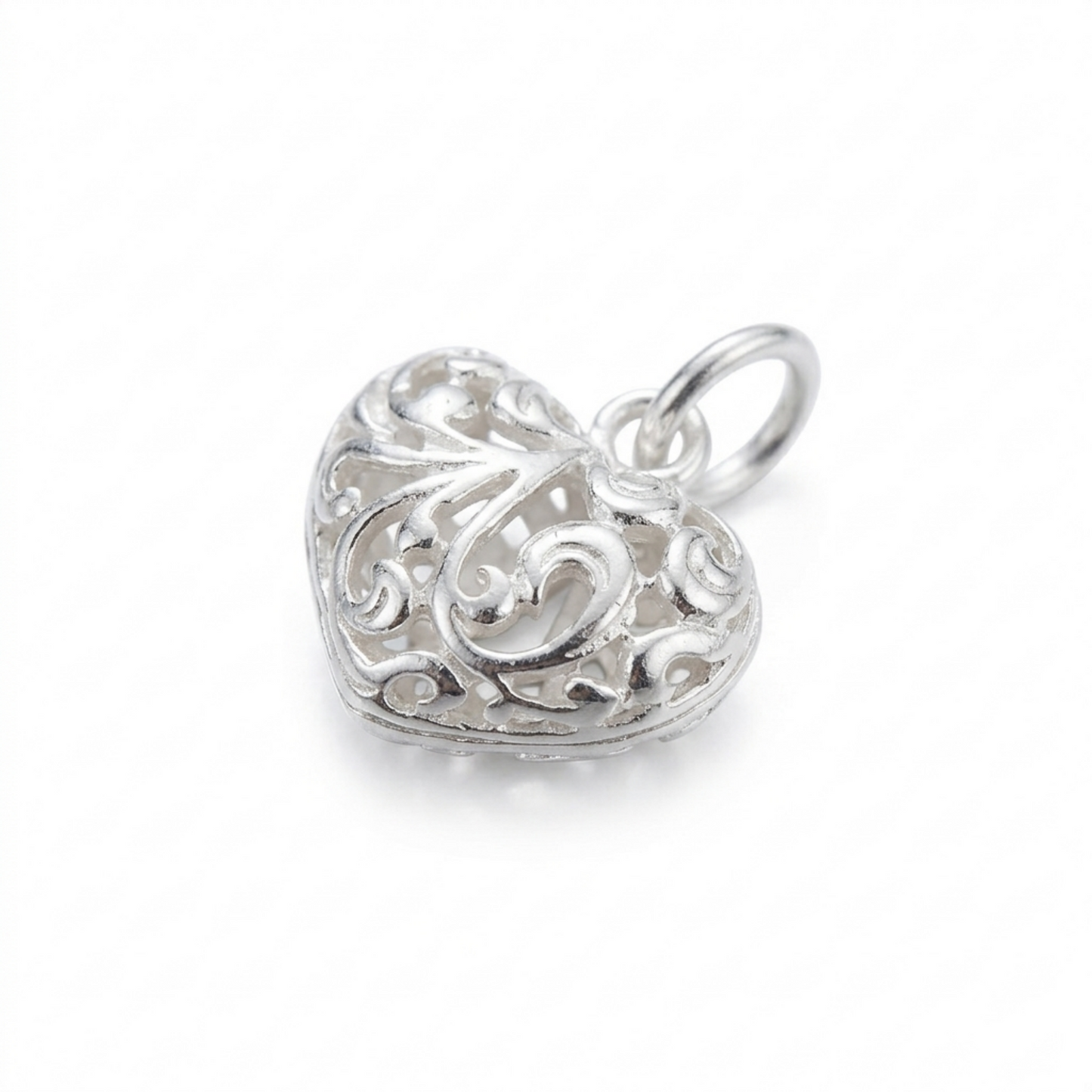 Silver heart pendant with ornate filigree floral detailing and bail ring