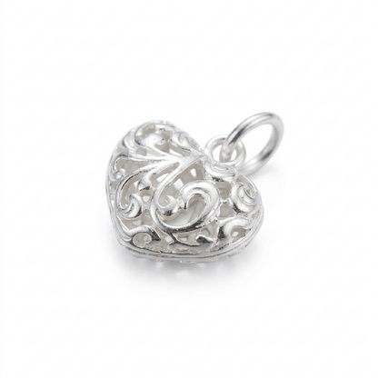 Silver heart pendant with ornate filigree floral detailing and bail ring
