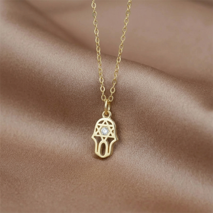 Gold necklace with hamsa protection charm pendant and clear stone