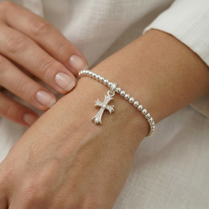 Silver beaded bracelet with a small cross charm and tiny pavé details