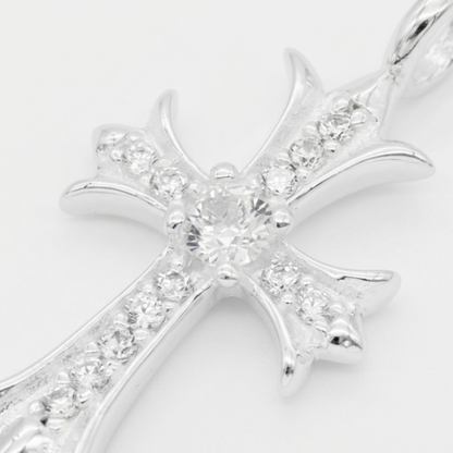 Close-up of silver cross pendant center with round stones and surrounding pavé