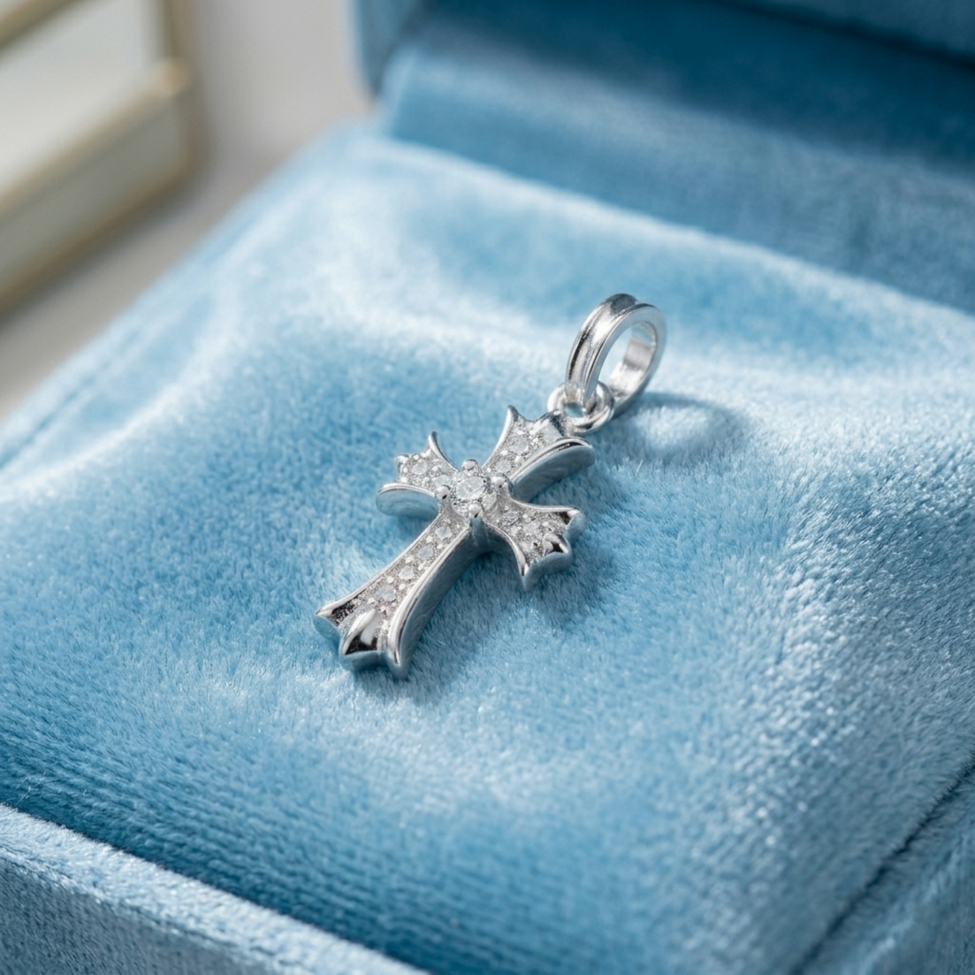 Silver cross pendant with pavé stones and round center, on blue velvet