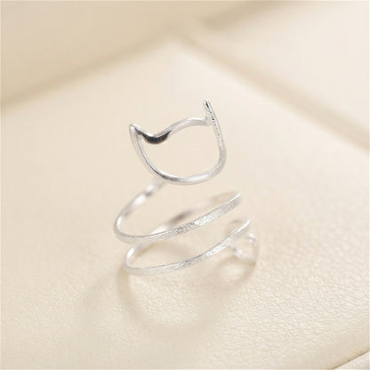 Silver-tone kitten wraparound ring viewed from above, cat-face and spiral tail.