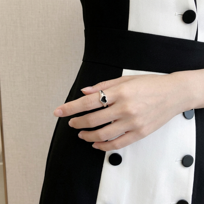 Silver heart ring with black heart inset worn on finger