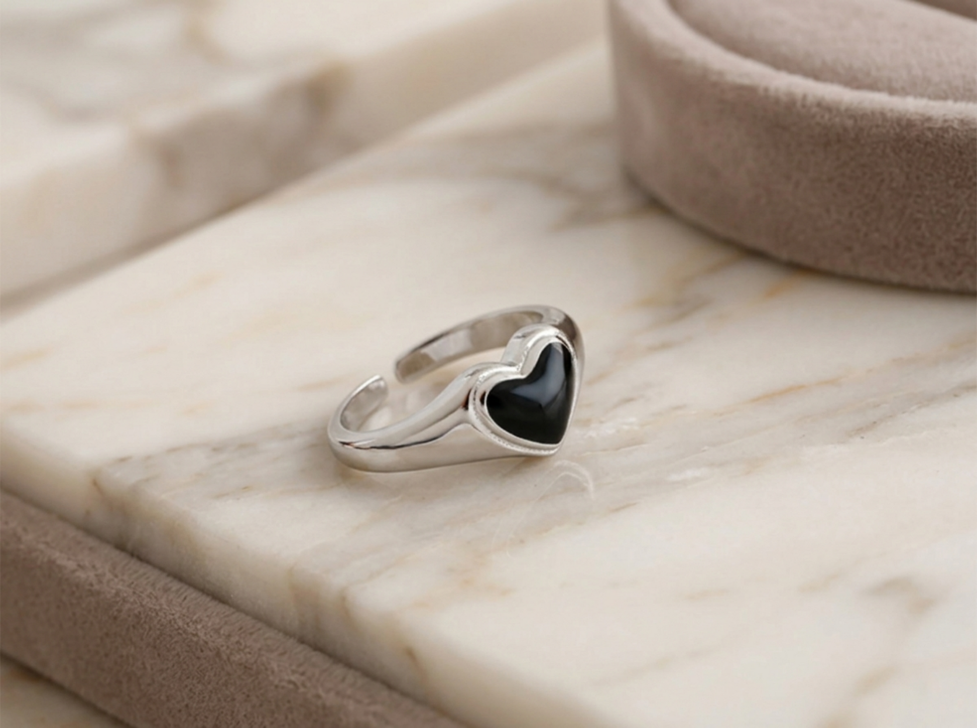 Silver heart ring with black center, side profile view